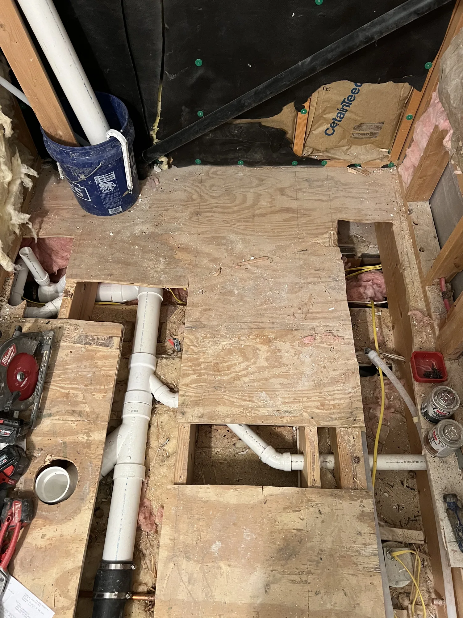 Basement bathroom rough in with PVC drain lines and stud framing during a Pittsburgh basement finish
