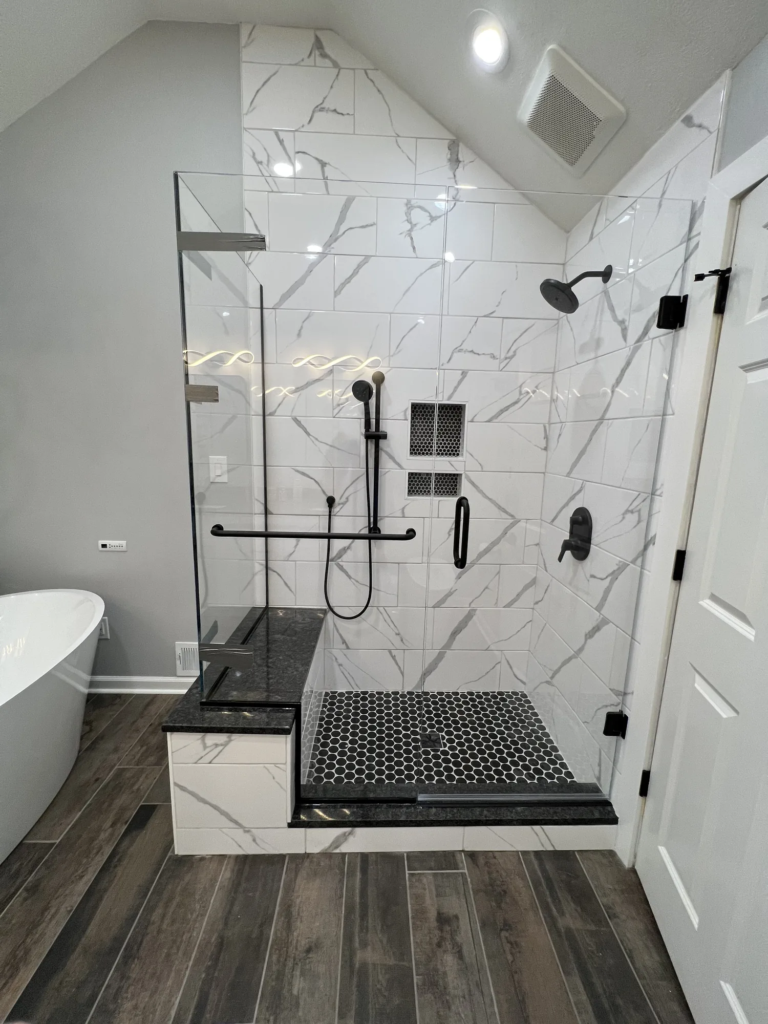 Finished walk in tile shower with black fixtures in a remodeled Allison Park bathroom