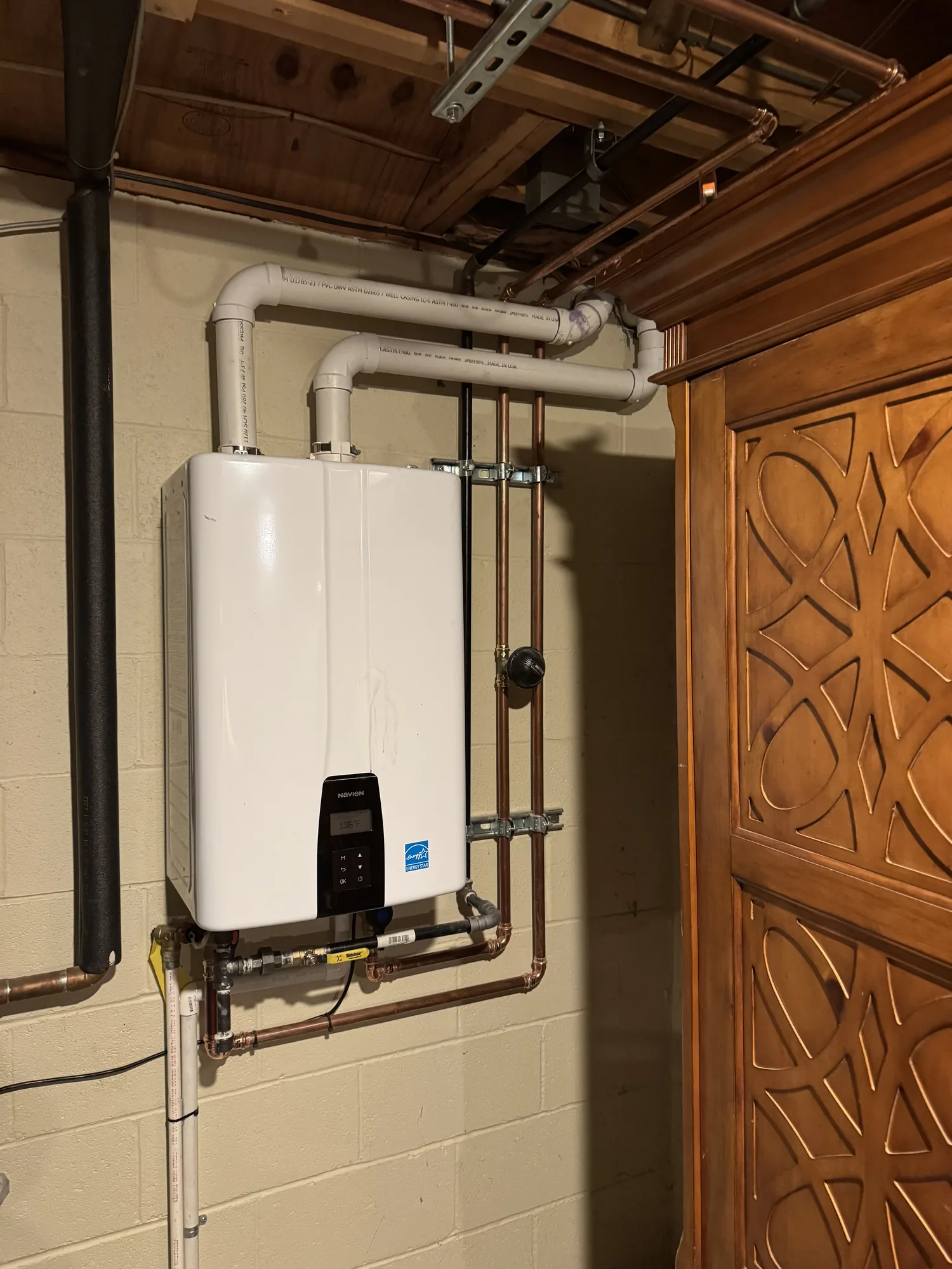Tankless water heater with new gas and copper water line connections in a North Hills basement