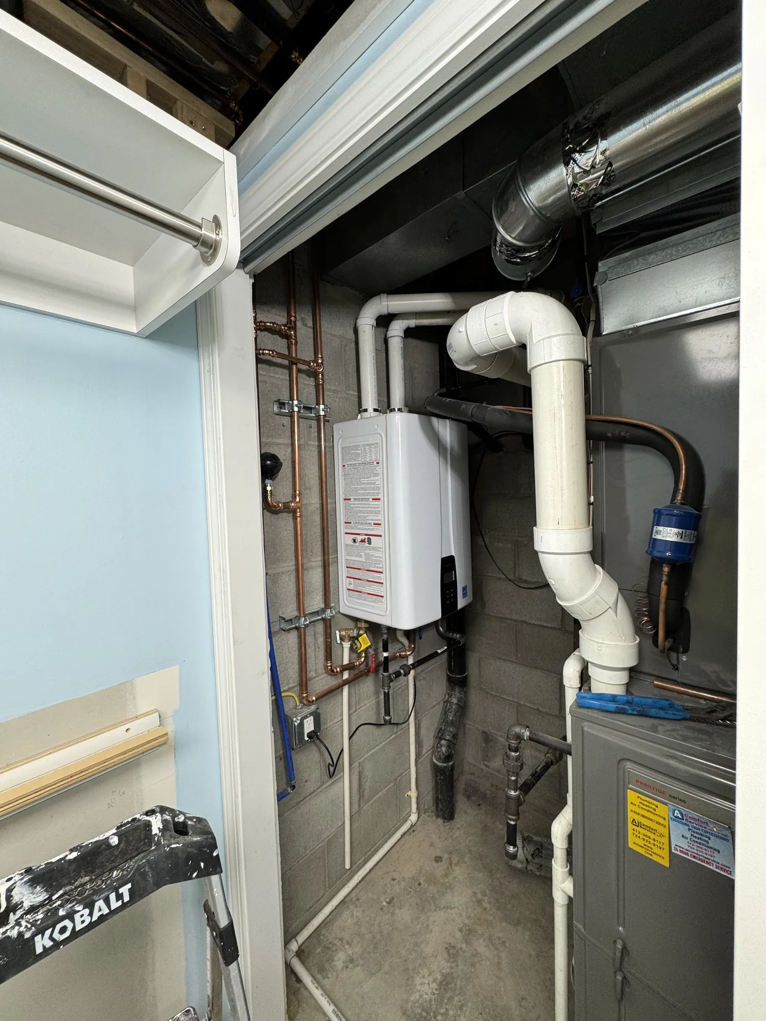 Basement utility area with tankless water heater and copper piping in a North Hills Pittsburgh home