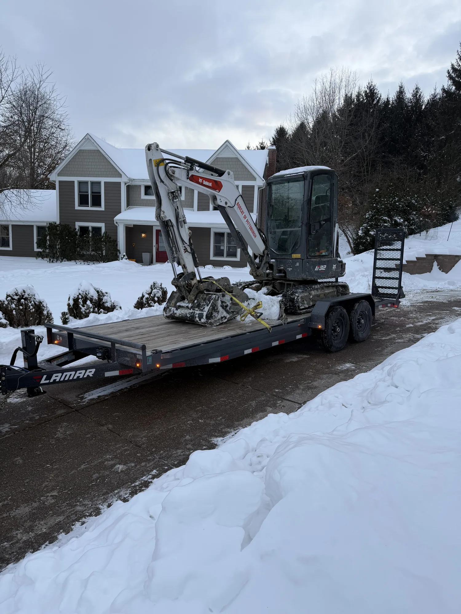 Compact excavator loaded on a trailer for a winter job in the Pittsburgh North Hills