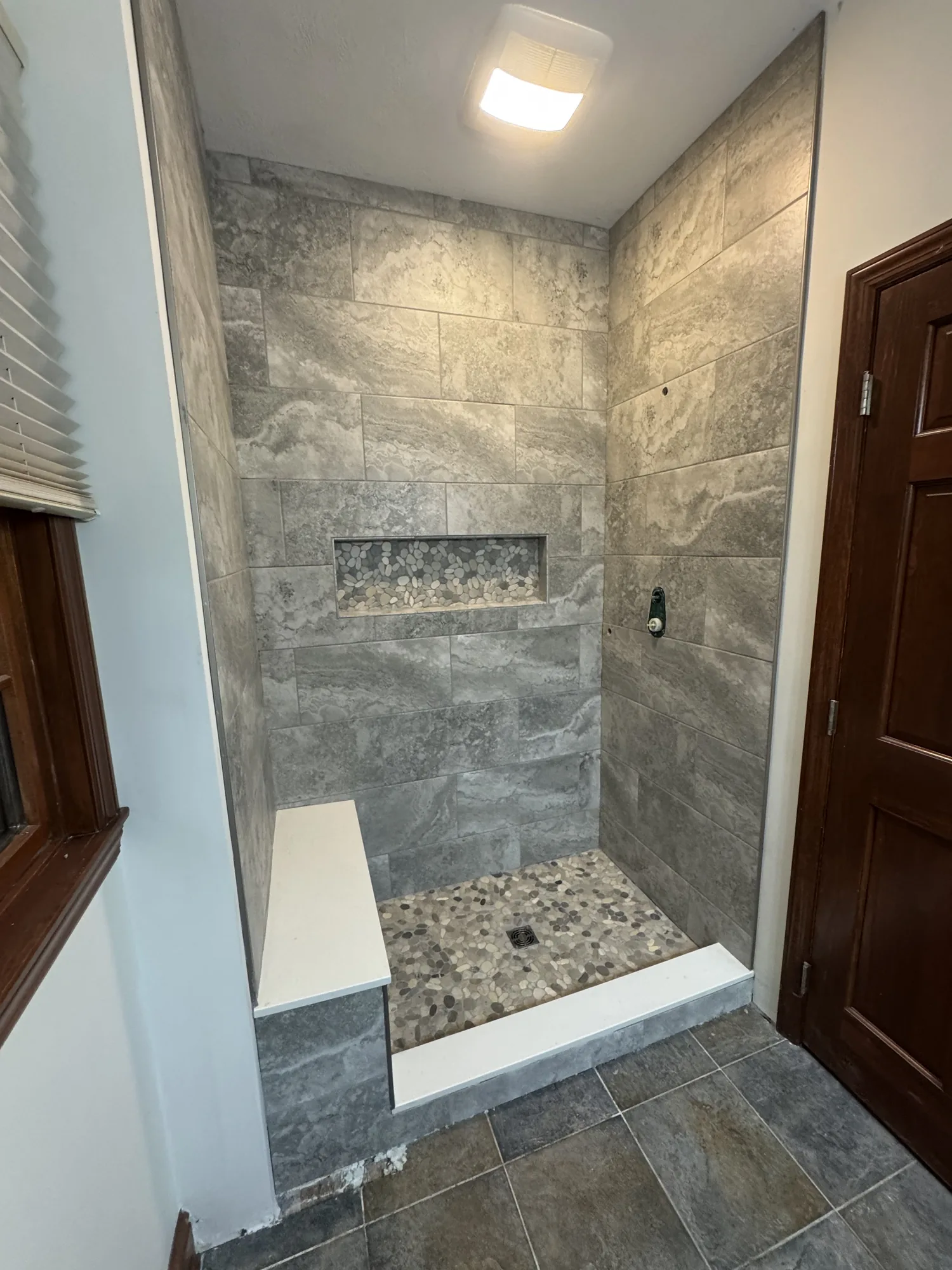 Tiled walk in shower with pebble mosaic niche during a bathroom remodel near Pittsburgh