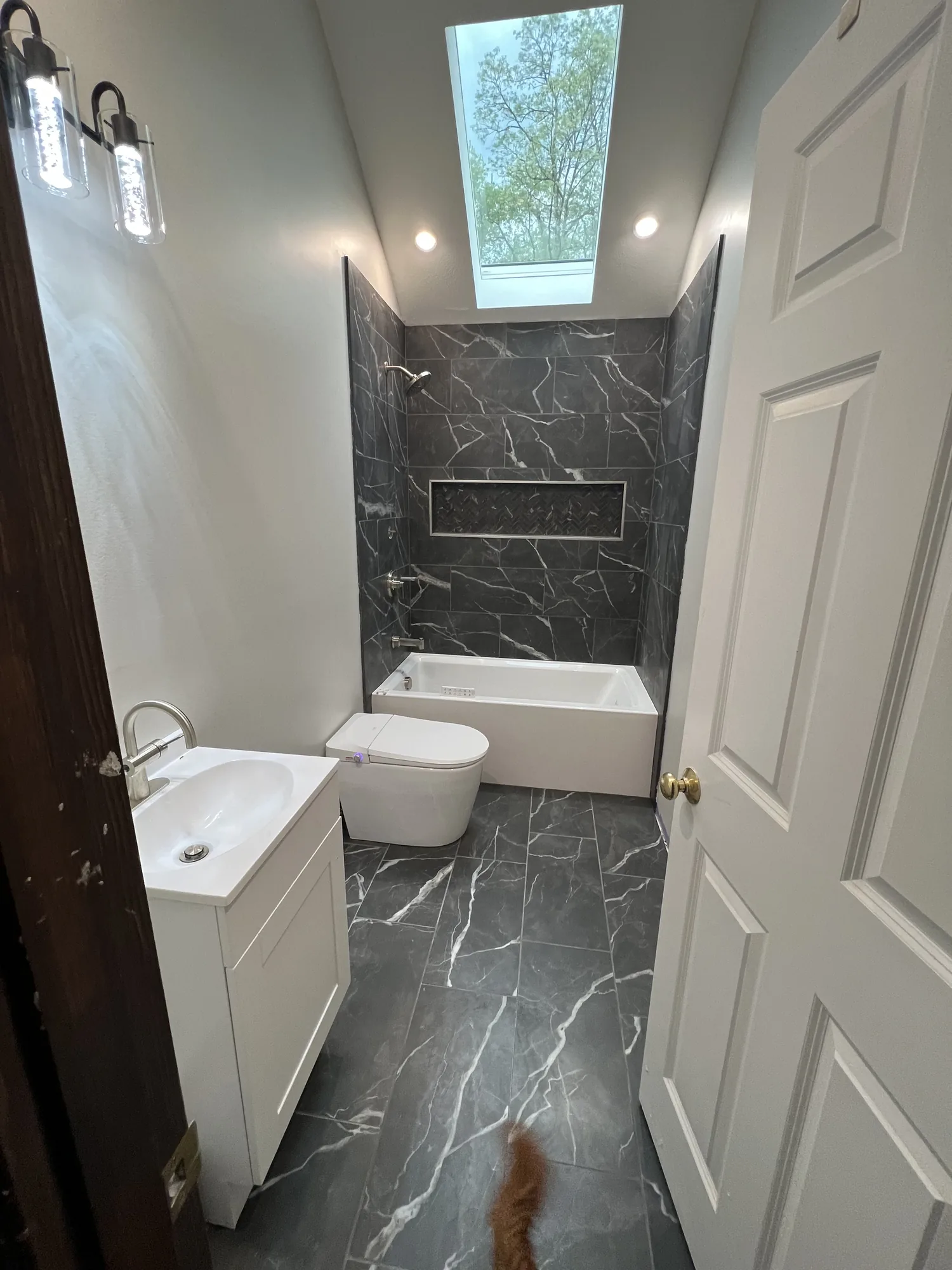 Finished bathroom remodel with dark marble look tile and a walk in shower near Pittsburgh