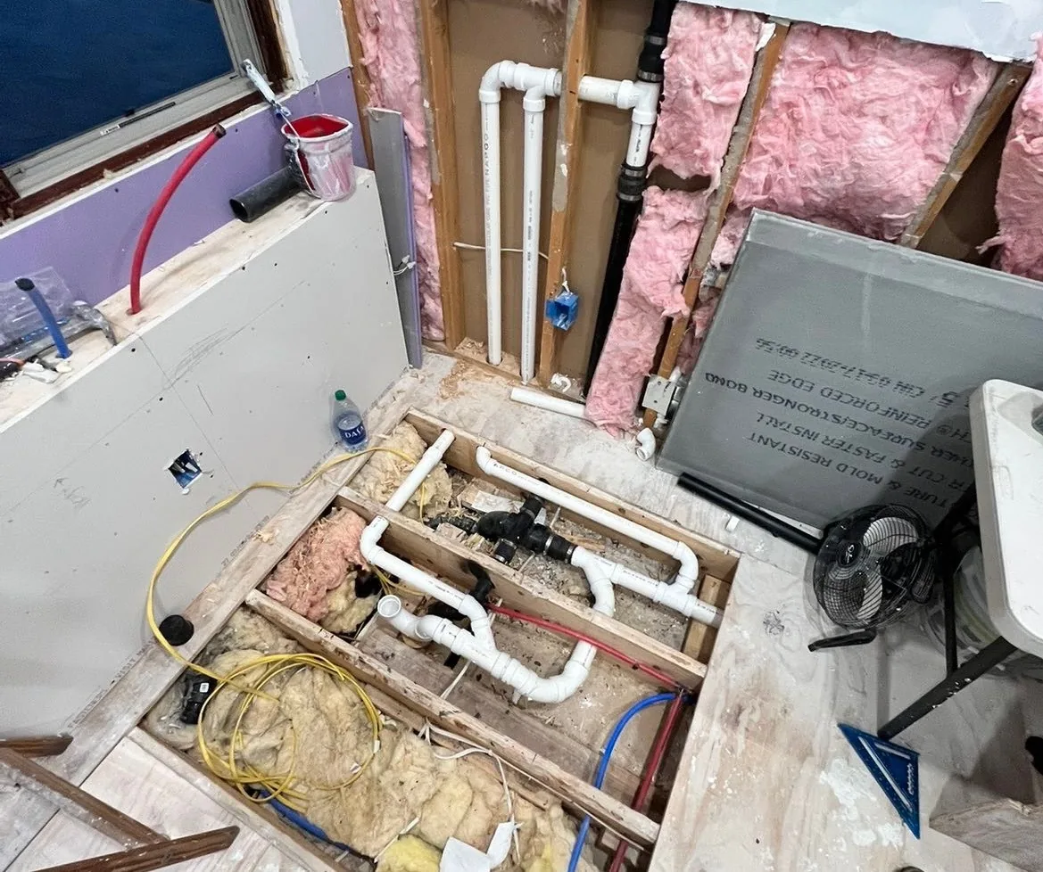Bathroom gutted to the joists with new PVC drain lines and PEX supply during a remodel