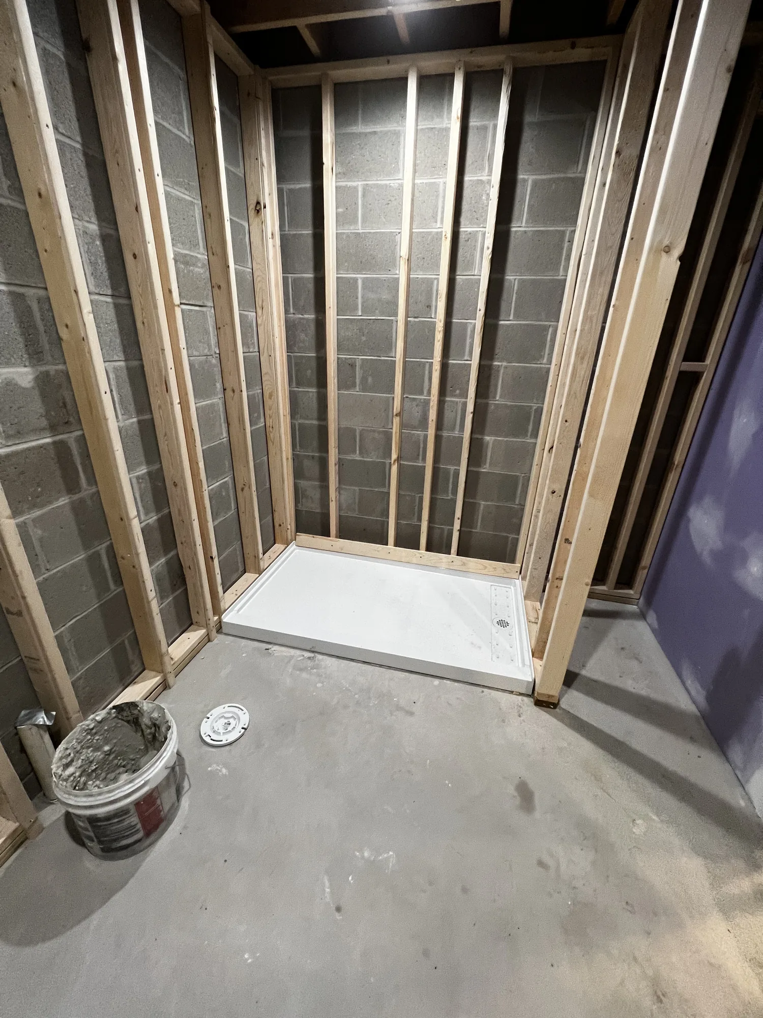 New wood framing built against a block foundation wall during a basement finishing project