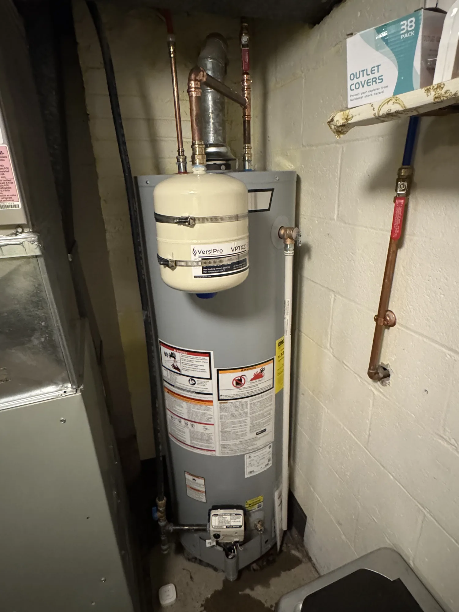 Gas water heater with expansion tank and copper water lines in a home utility room