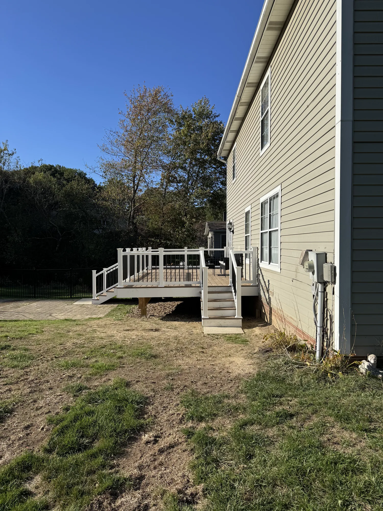 Raised deck with white pergola on a hillside home after the slope was cut and graded