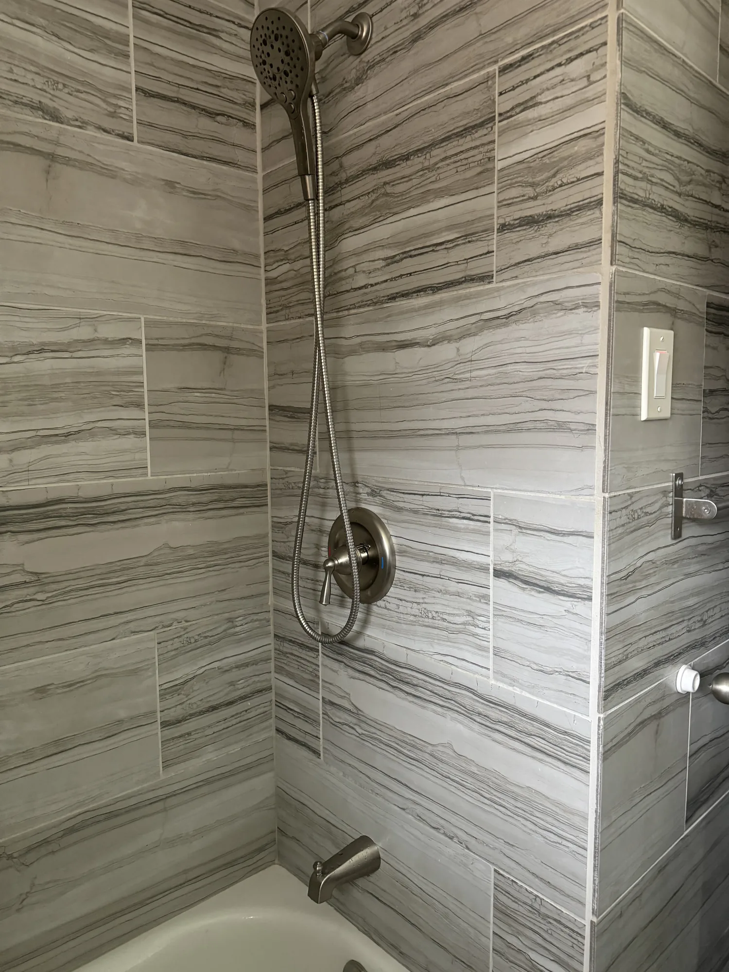 Finished tile tub and shower surround with brushed nickel fixtures in a North Hills bathroom remodel