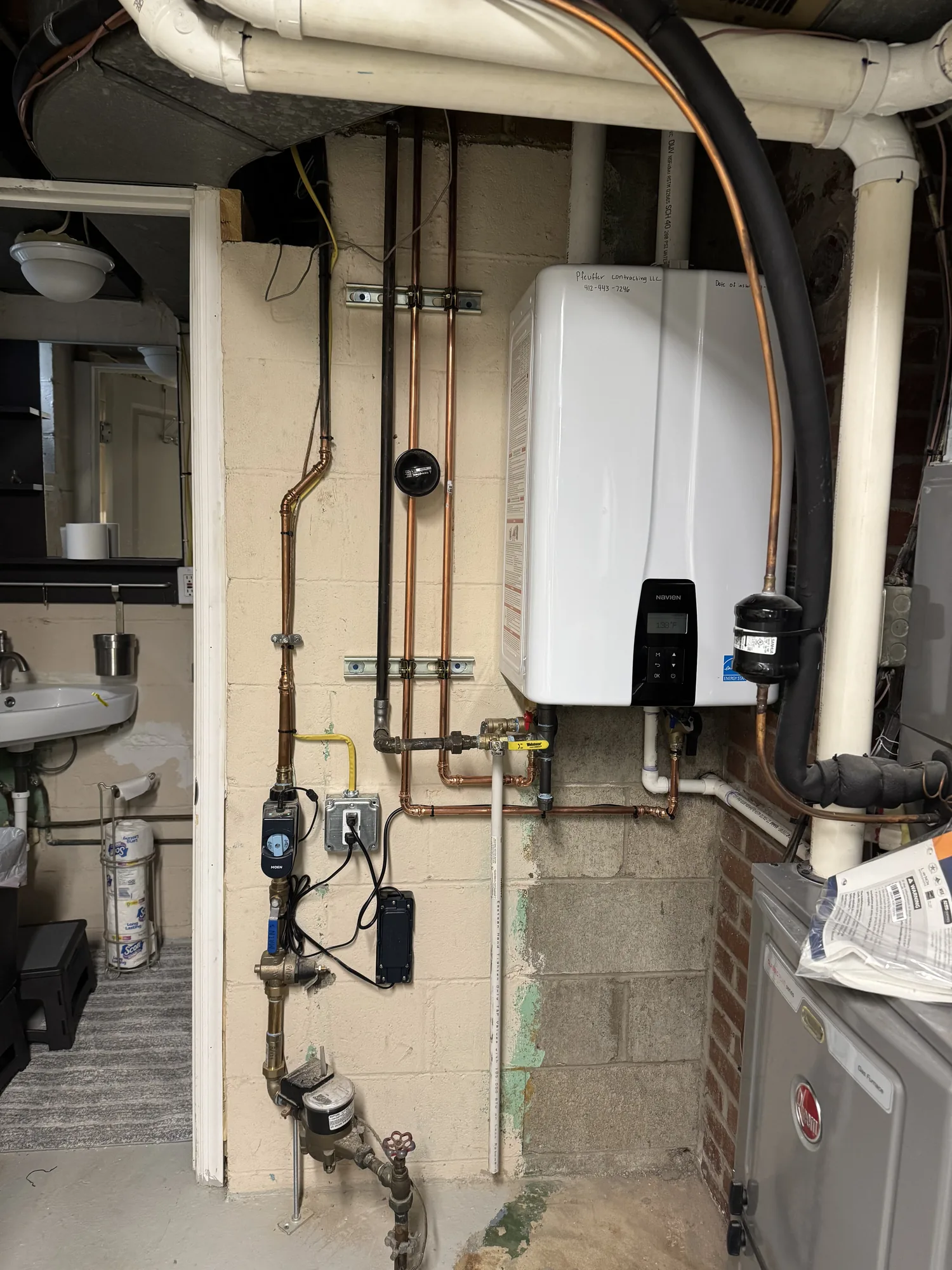 Basement mechanical wall with new boiler, water meter, and gas piping in a Pittsburgh home