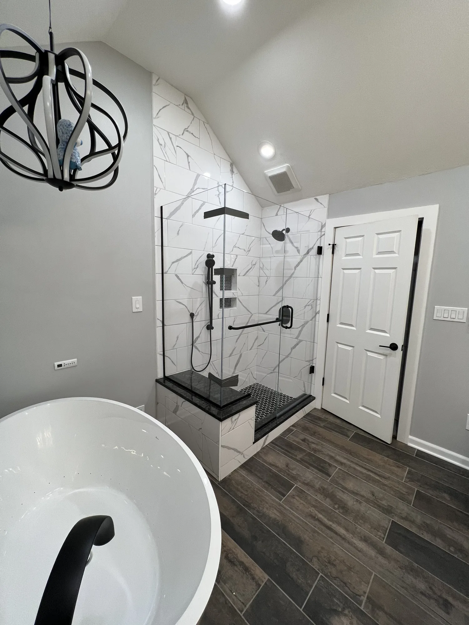 Remodeled bathroom with freestanding tub, walk in tile shower, and matte black fixtures in the North Hills