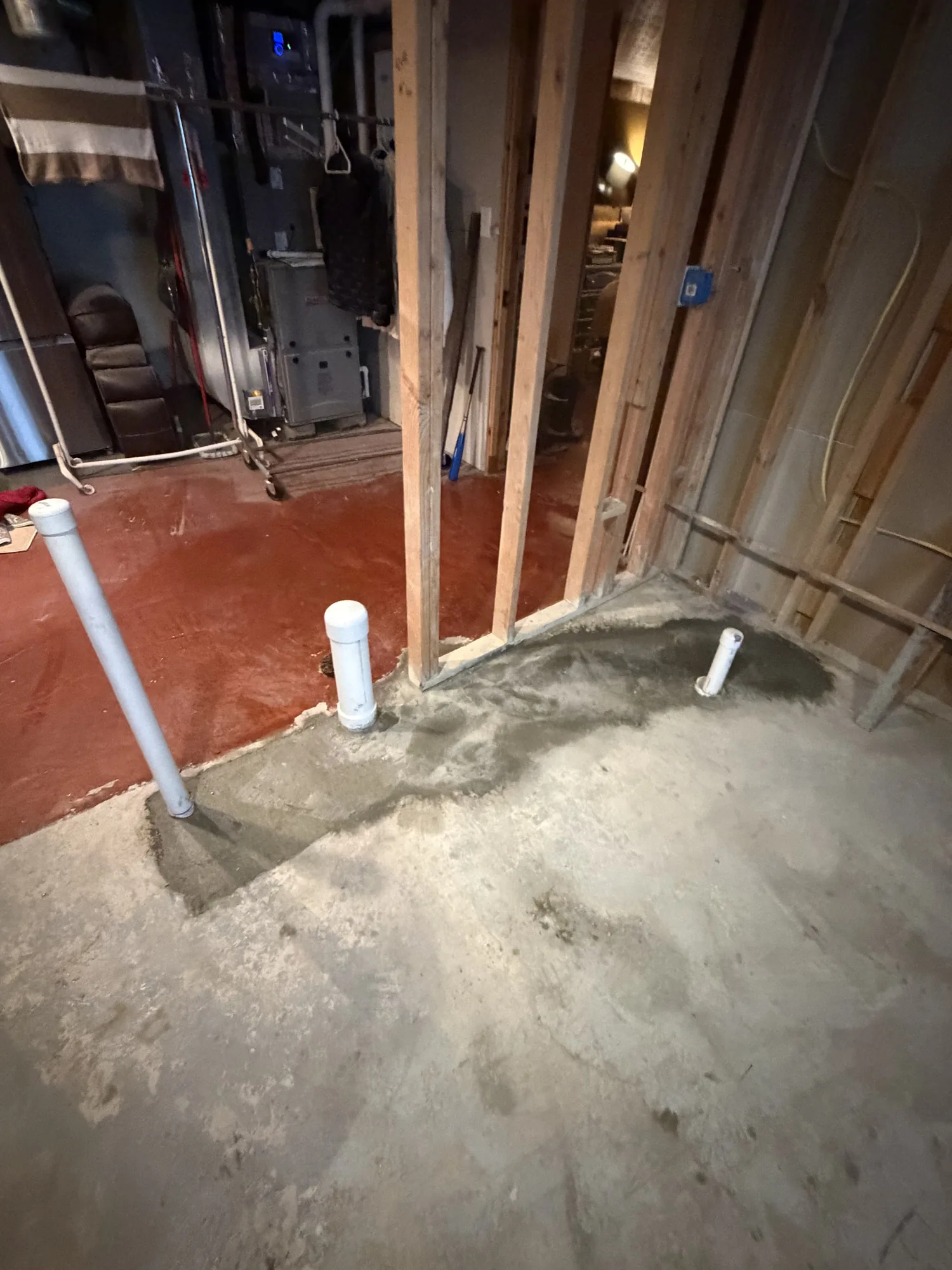 Basement slab trenched and patched for new drain lines during a bathroom addition